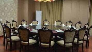 A conference room with a round table, chairs, and a chandelier.