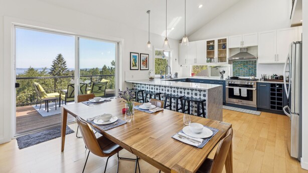 A modern kitchen with a large island, white cabinetry, and pendant lighting. - 4-Bd w/ AC, Walk to Light Rail, Yard, VIEW Dog OK! (Seattle)