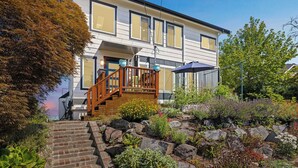 A two-story house with a wooden staircase leading to a balcony. - 4-Bd w/ AC, Walk to Light Rail, Yard, VIEW Dog OK! (Seattle)