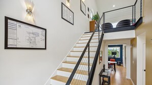 A staircase with a black railing, wooden steps, and a framed architectural drawing on the wall. - 4-Bd w/ AC, Walk to Light Rail, Yard, VIEW Dog OK! (Seattle)