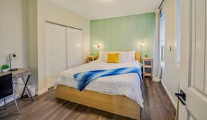 A bedroom with a bed, bedside tables, a desk, and a chair. - Stylish Deluxe Kitchen /King Bed/Laundry/Free Parking (Renton)