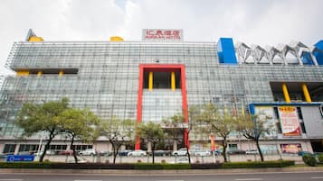 A modern hotel with a prominent red and yellow entrance, multiple floors, and a mix of glass and metal construction.