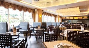 A restaurant with indoor seating, a bar area, and large windows. - Huiquan Hotel (Zhongshan)