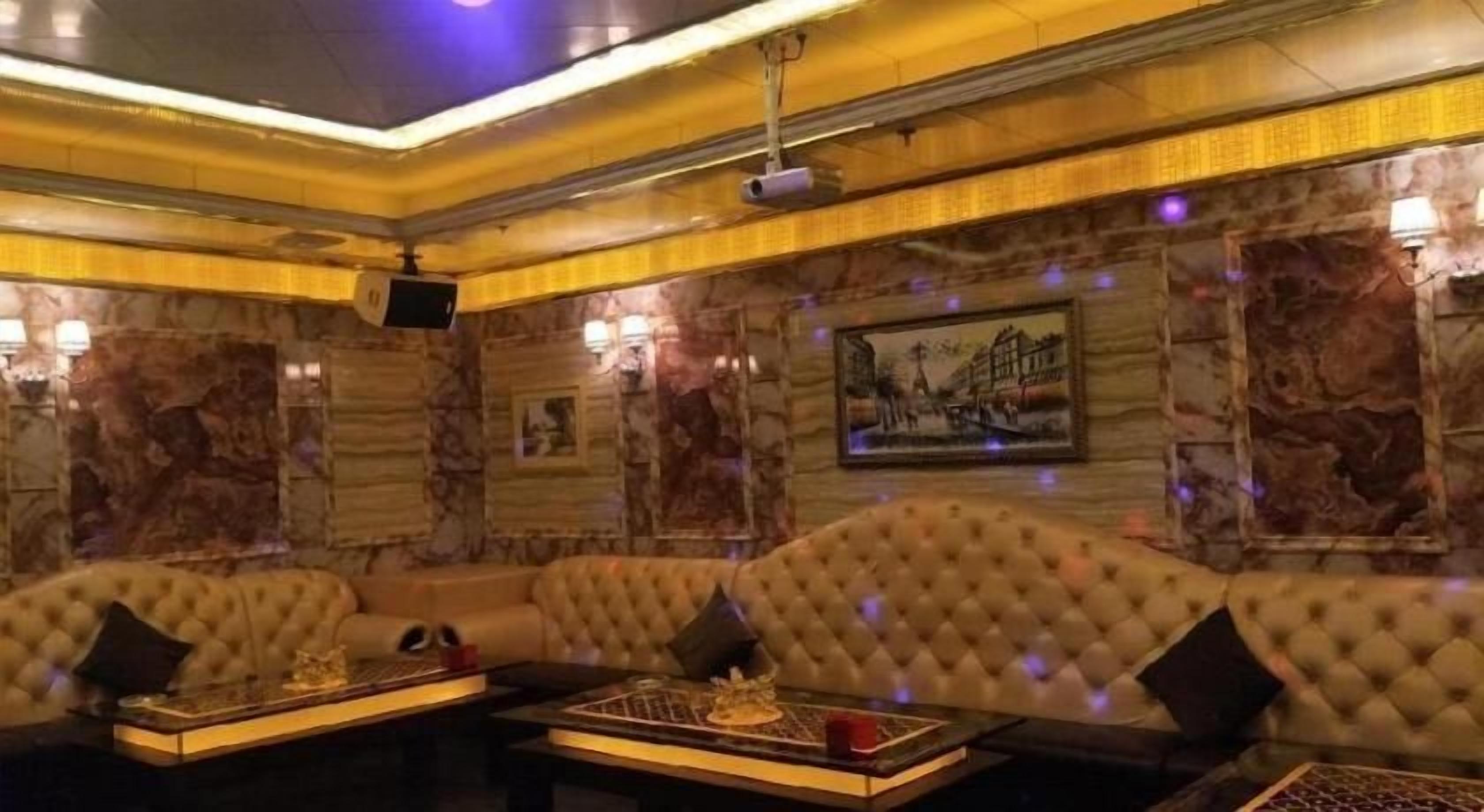 Una habitación lujosa con un sofá grande, una mesa de centro y un televisor.