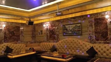 Una habitación lujosa con un sofá grande, una mesa de centro y un televisor.
