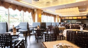 A restaurant with multiple seating areas, including tables and booths, and a bar area.