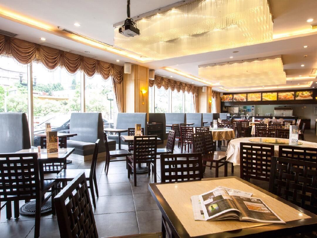 A restaurant with indoor seating, a bar area, and a view of the outdoors.