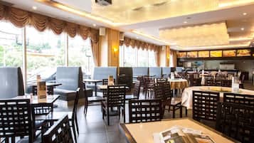 A restaurant with indoor seating, a bar area, and a view of the outdoors.