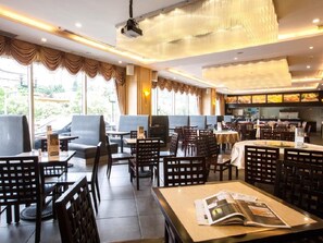 Un restaurant doté d’une salle à manger intérieure, d’un bar et offrant une vue sur l’extérieur.