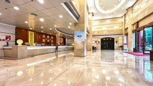 A spacious lobby with a reception desk, a KTV area, and a modern ceiling design. - Huiquan Hotel (Zhongshan)