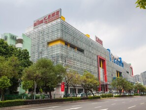 Ein modernes Hotel mit Glasfassade, mehreren Balkonen und einem markanten, roten Eingang.