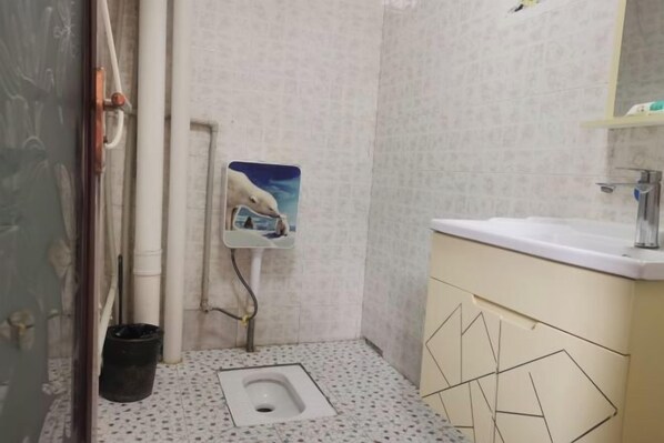 A small bathroom with a toilet, a sink, and a mirror. - Miyi lnn (Xiaojin)