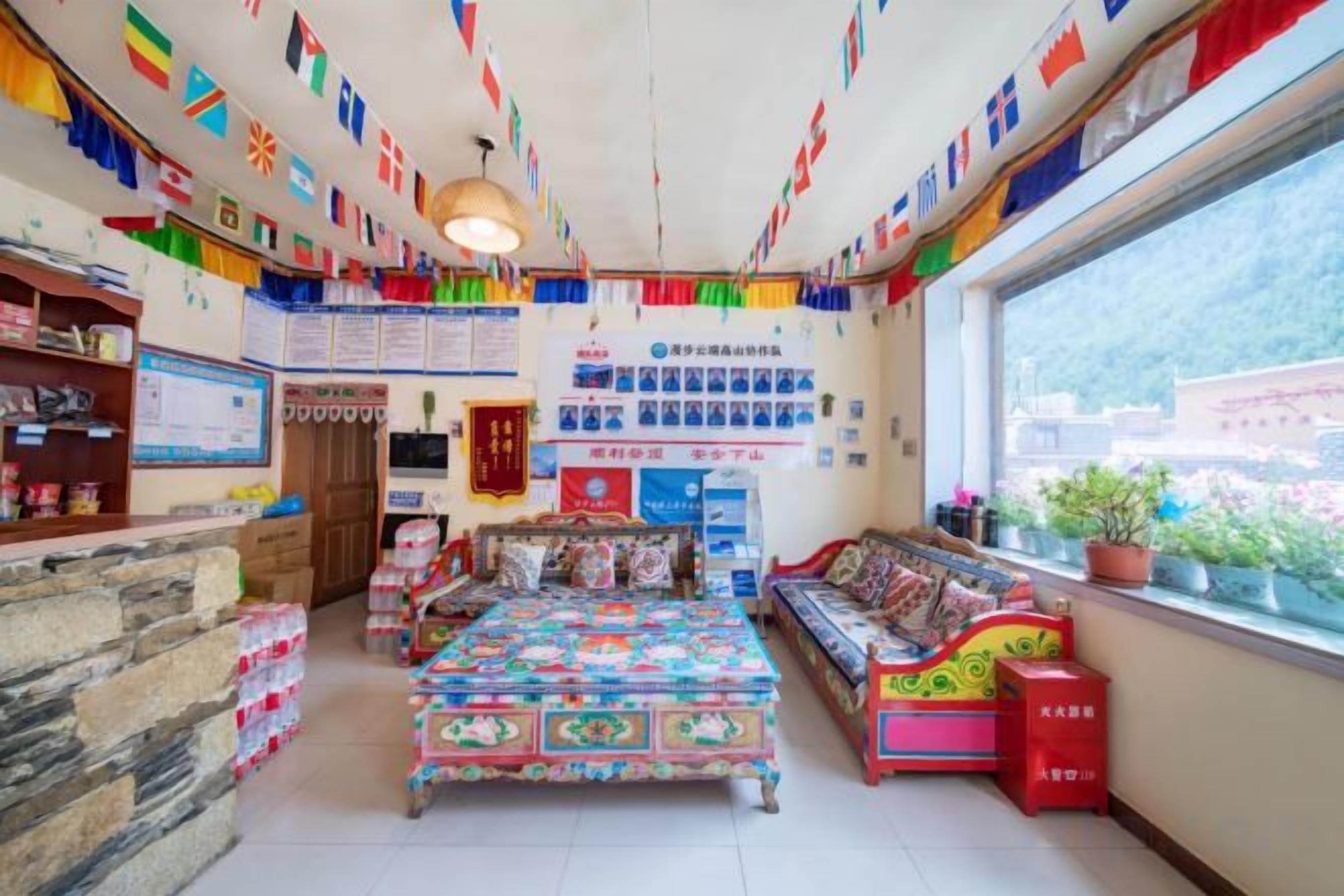 A room with a bed, a sofa, a window with a view, and various items on the walls.