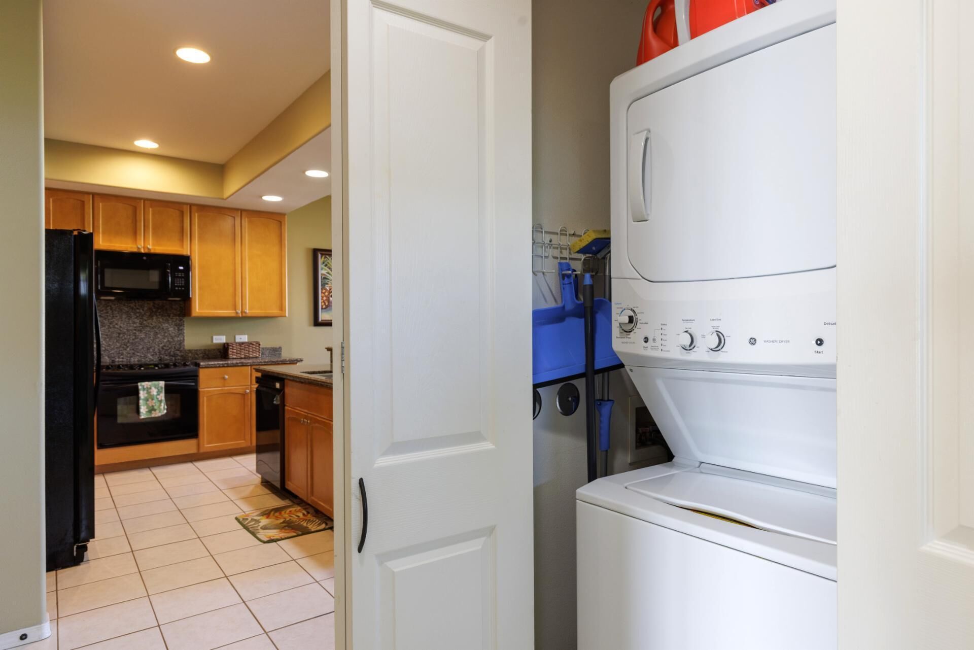 A kitchen with wooden cabinets, a black refrigerator, a microwave, and a stove.