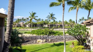 A resort with multiple-story buildings, palm trees, and a lava rock garden. - Waikoloa Colony Villas Resort by KBM (Waikoloa)
