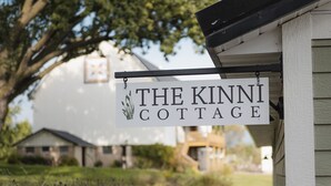 Une enseigne indiquant « The Kinni Cottage », avec un chemin menant à l’entrée.