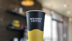 A coffee cup with the text "WHIDBEY COFFEE SINCE 1989" on a reflective surface. - Red Lion Inn & Suites Adairsville (Adairsville)