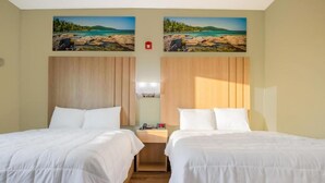 A hotel room with two beds, wooden headboards, and a nightstand with a lamp. - Red Lion Inn & Suites Adairsville (Adairsville)