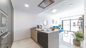 Una cucina moderna con isola centrale, forno integrato e un'ampia finestra che offre vista sulla città.