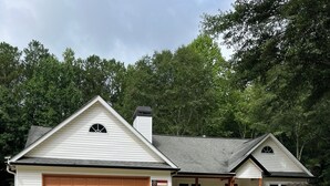 A two-story house with a garage, a front porch, and a well-maintained lawn.