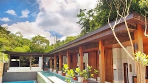 A modern outdoor pool area with a covered seating area and potted plants. - Fuli Hot Spring Resort (Nantou)