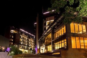 A modern building with multiple floors, large windows, and a well-lit entrance area.