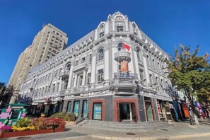 A historic building with a central entrance, multiple floors, and a flag. - Jinjiang Inn Select (Harbin Central Avenue Pedestrian Street Airport Bus Station) (Harbin)
