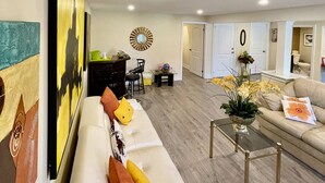 A living room with a sofa, coffee table, and artwork on the wall. - Charming B&B with WiFi/Kitchenette and AC in Marvelous Niagara-on-the-Lake (Niagara-on-the-Lake)