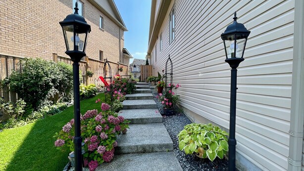 A pathway flanked by two-story buildings with brick and siding exteriors, leading to a gated entrance. - Charming B&B with WiFi/Kitchenette and AC in Marvelous Niagara-on-the-Lake (Niagara-on-the-Lake)