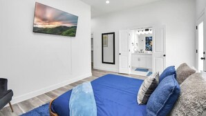 Un dormitorio con una cama grande, un cuadro y vistas al baño.