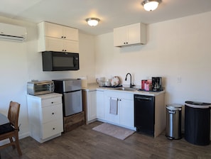 A compact kitchen with white cabinets, a microwave, toaster, refrigerator, sink, and dishwasher. - "Barndo" located close to Coeur D' Alene yet set in a wooded atmosphere. (Coeur d'Alene)