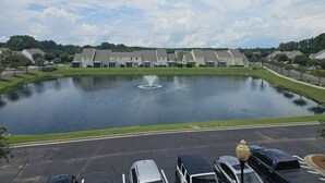 Zona residencial com um lago e casas ao fundo.