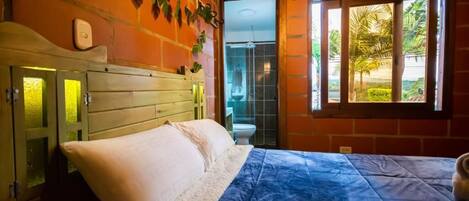 A bedroom with a bed, a window, and a view of the outside.