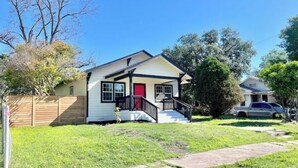 A single-story house with a red door, white exterior, and a front porch. - Renovated home 5 min downtown
 (San Antonio)