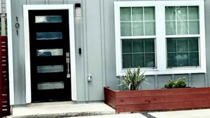A building with a black door and a window with blinds. - Brand new home 6 min downtown (San Antonio)