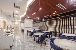 A modern interior with marble flooring, round tables, and blue chairs. - Starway Hotel (Hangzhou Binjiang Jiangnan Avenue) (Hangzhou)