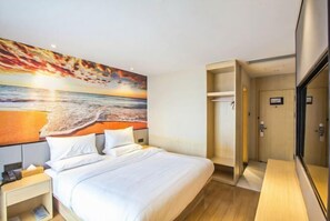 A hotel room with a bed, a nightstand, a wardrobe, and a large painting of a sunset over the ocean. - Starway Hotel (Hangzhou Binjiang Jiangnan Avenue) (Hangzhou)