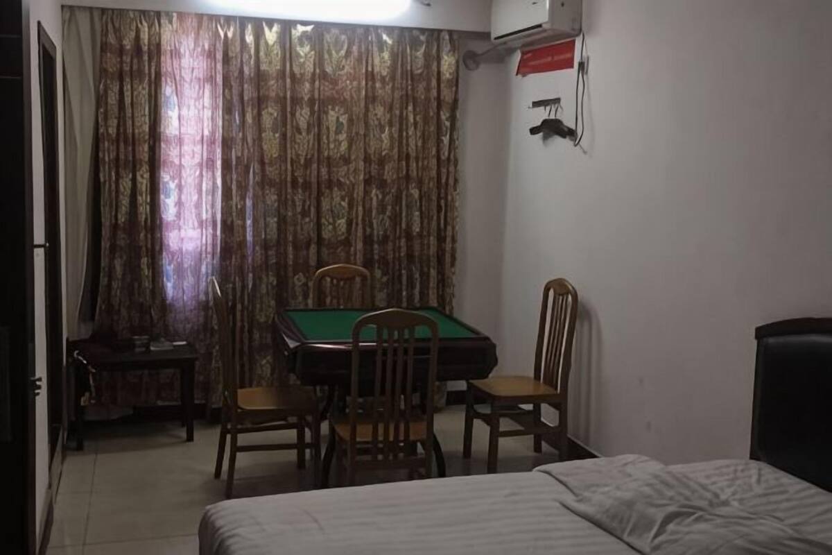 A room with a bed, a pool table, and a chair.