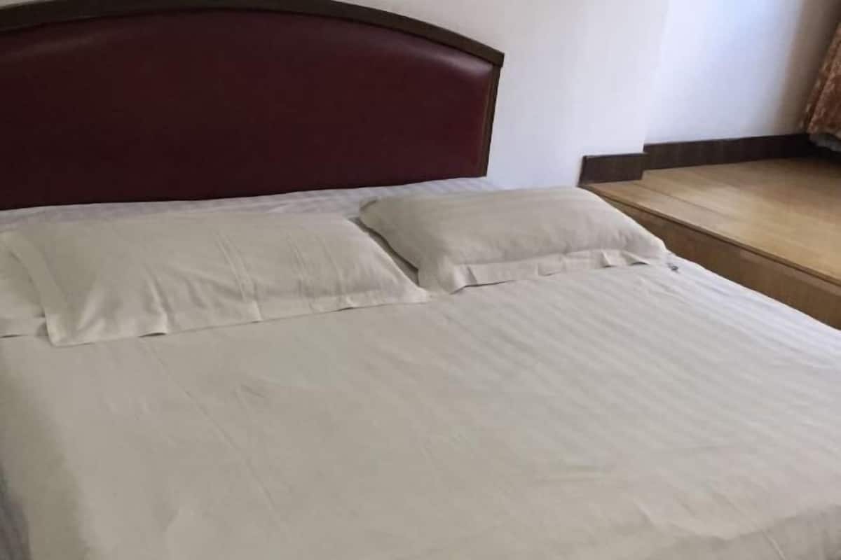 A bed with a dark headboard and two pillows.
