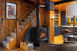 Ein gemütliches Interieur mit einer Holztreppe, einem Kamin und einer Küchenzeile.