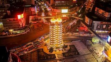 A multi-story building with a central tower, surrounded by a busy urban street at night.