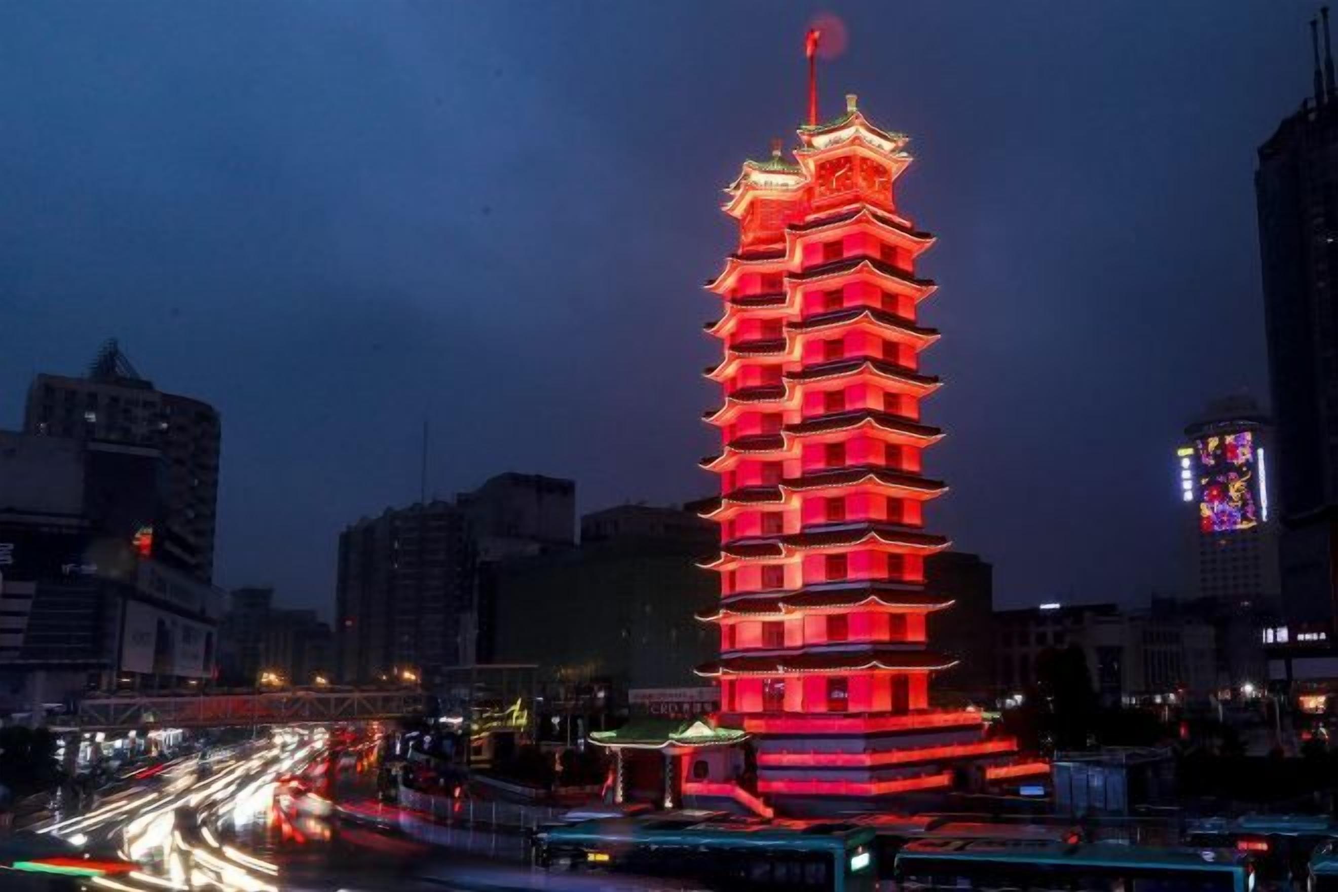 A multi-tiered pagoda-style building with a red-lit exterior, surrounded by a cityscape with visible traffic.
