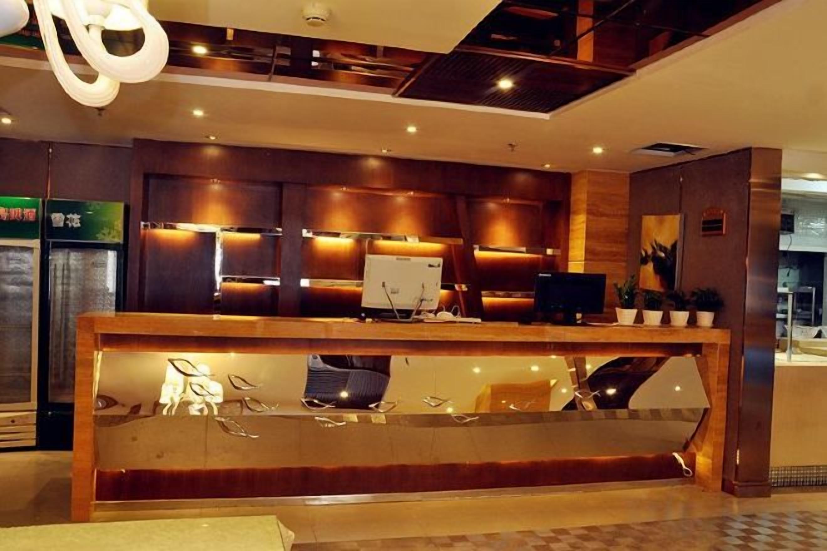 A reception desk with a computer, a glass display case, and a seating area.
