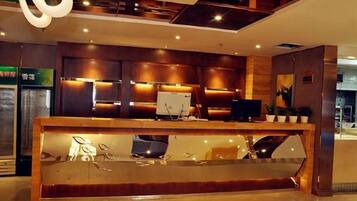 A reception desk with a computer, a glass display case, and a seating area.