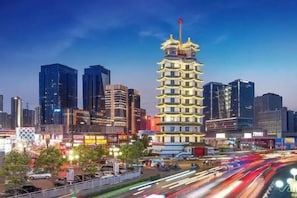 Un edificio de varios pisos con un techo de estilo pagoda distintivo, rodeado de modernos rascacielos.