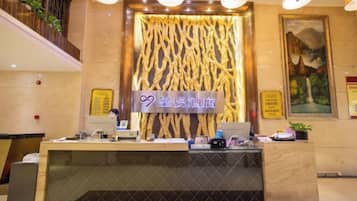 A hotel reception desk with a modern design, a digital display, and a decorative wall.