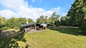 A modern house with a covered patio, a fireplace, and a lawn. - 4 bedroom cozy home in Jægerspris (Jægerspris)