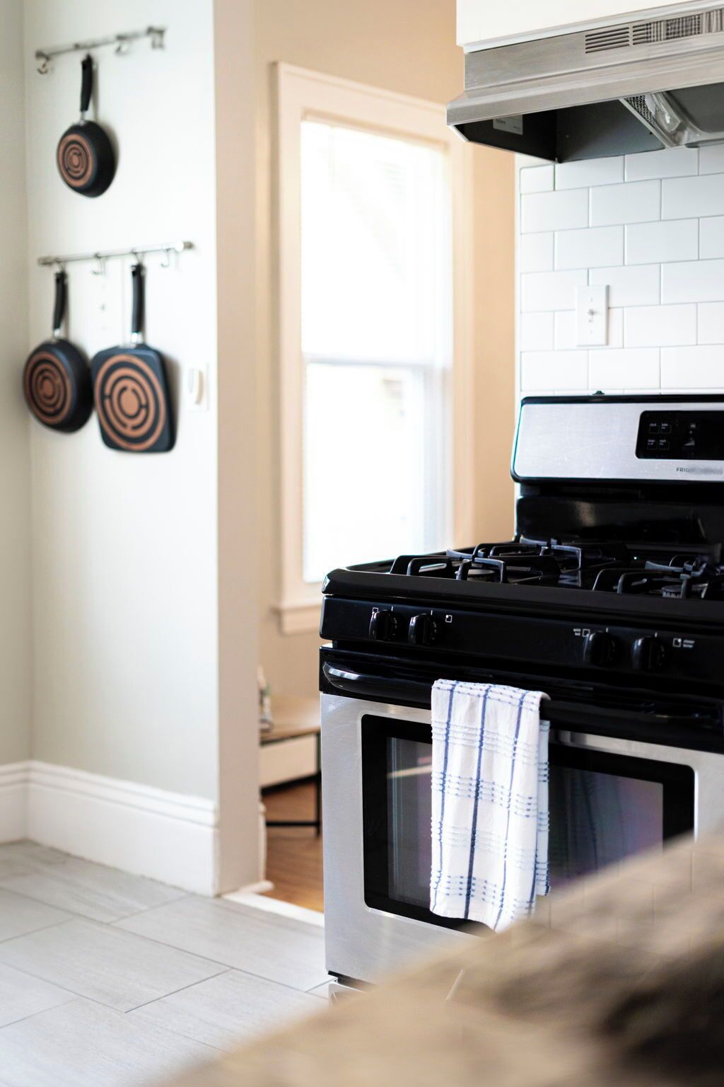A kitchen with a stove, oven, and hanging pots.