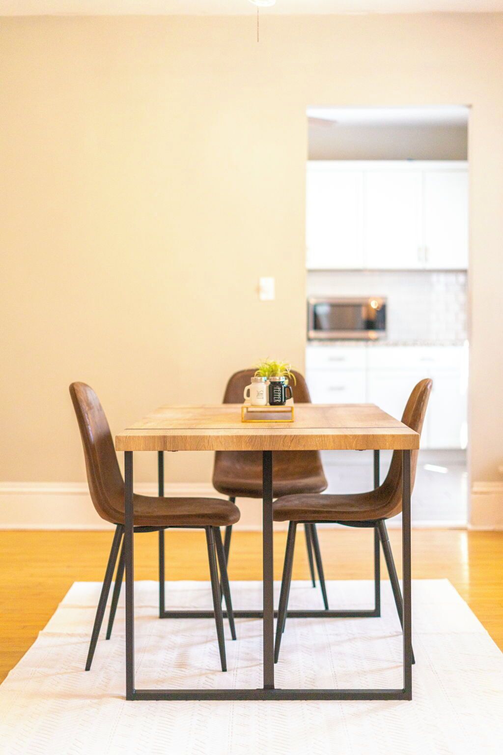 A dining table with four chairs, a coffee table, and a small plant.