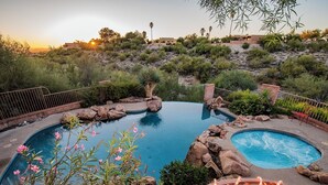 Une piscine dont le décor est constitué d’un paysage naturel, entourée de rochers et de plantes.